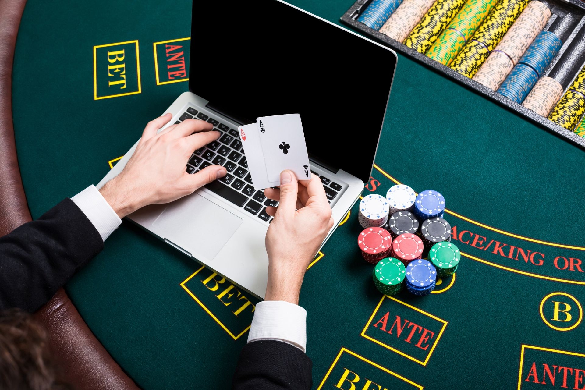 casino, online gambling, technology and people concept - close up of poker player with playing cards